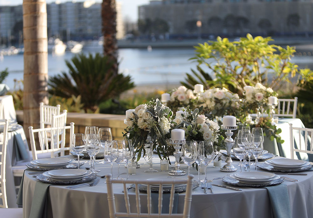 dining table setup with flower centerpiece with marina in background