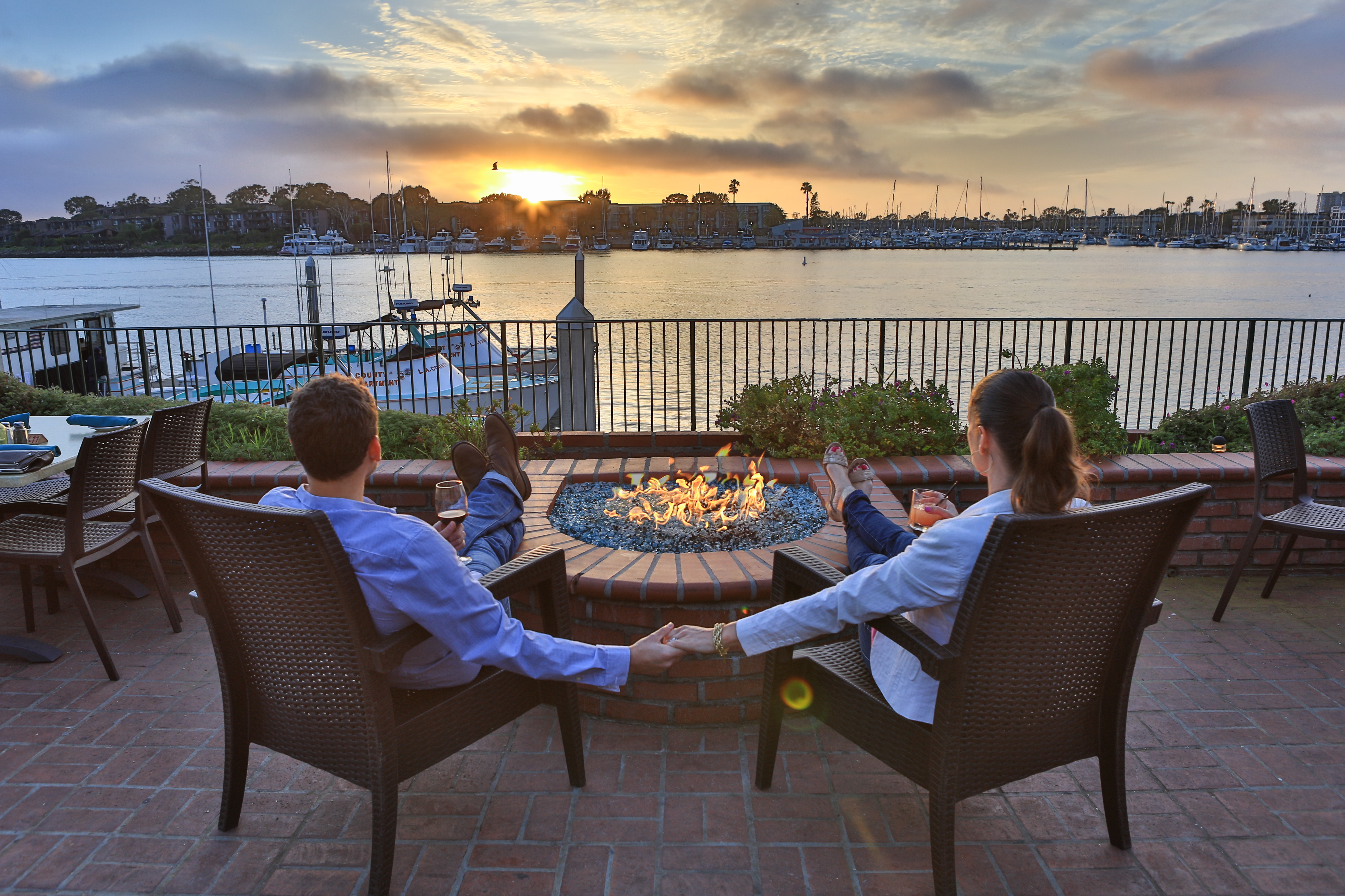 couple enjoying fireplace and drinks at sunset