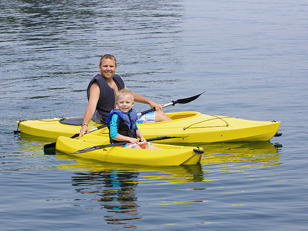 dad and young boy enjoying kayaking