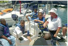 sailer teaching young children about sailing on boat