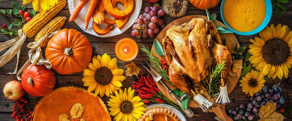 Thanksgiving in Marina del Rey: Roasted turkey with pumpkins and sunflowers on wooden table