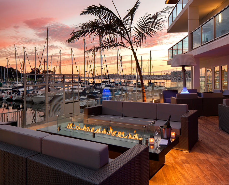 Valentine's Day dinner special outdoor seating and fire pit table at restaurant with boats and sunset sky