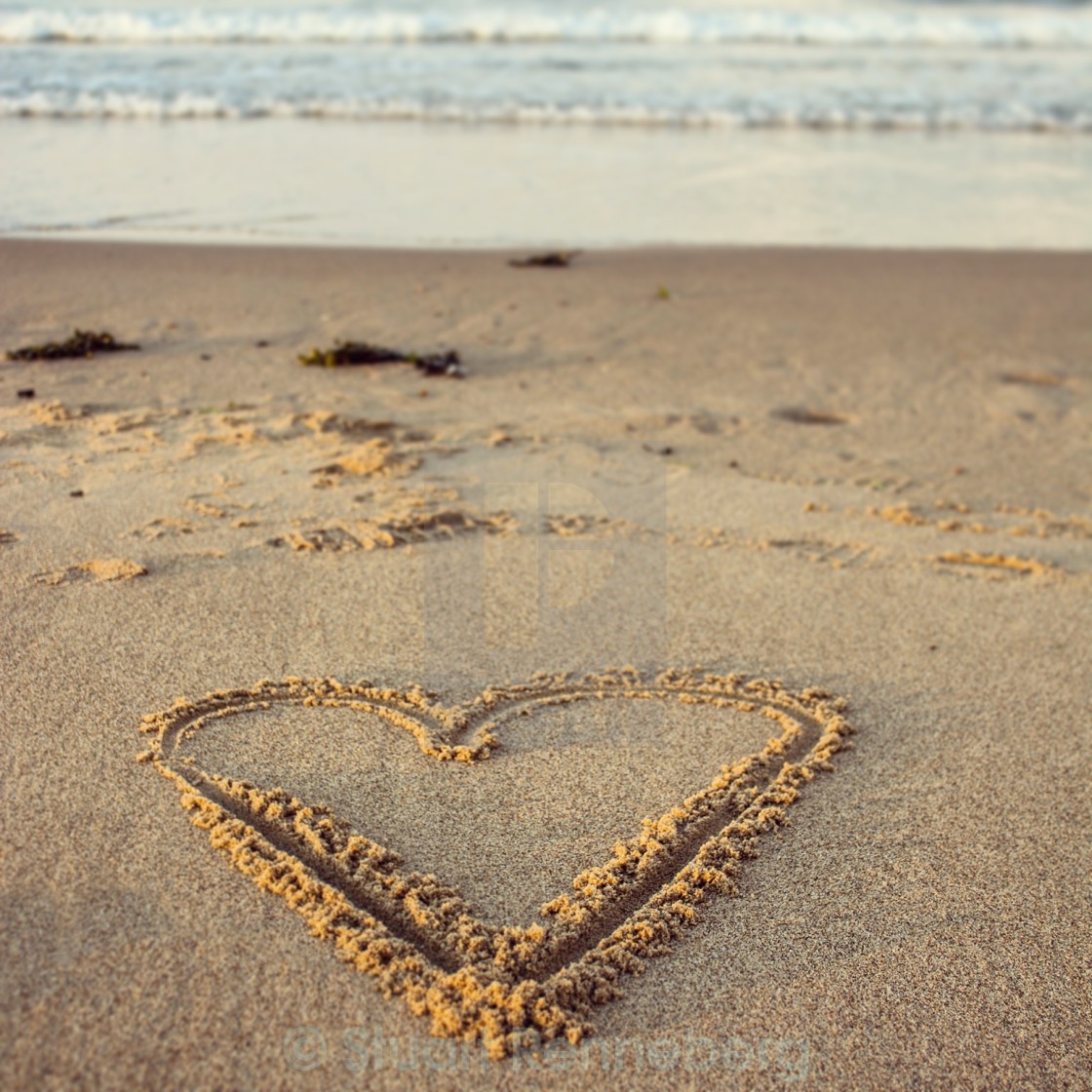 Heart shape drawn on sand at beach
