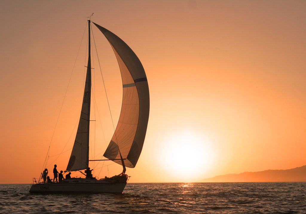 Sunset sail on ocean with sun setting in background