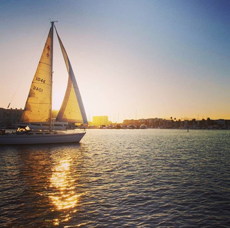 Sailboat in the Marina del Rey channel with sunset background