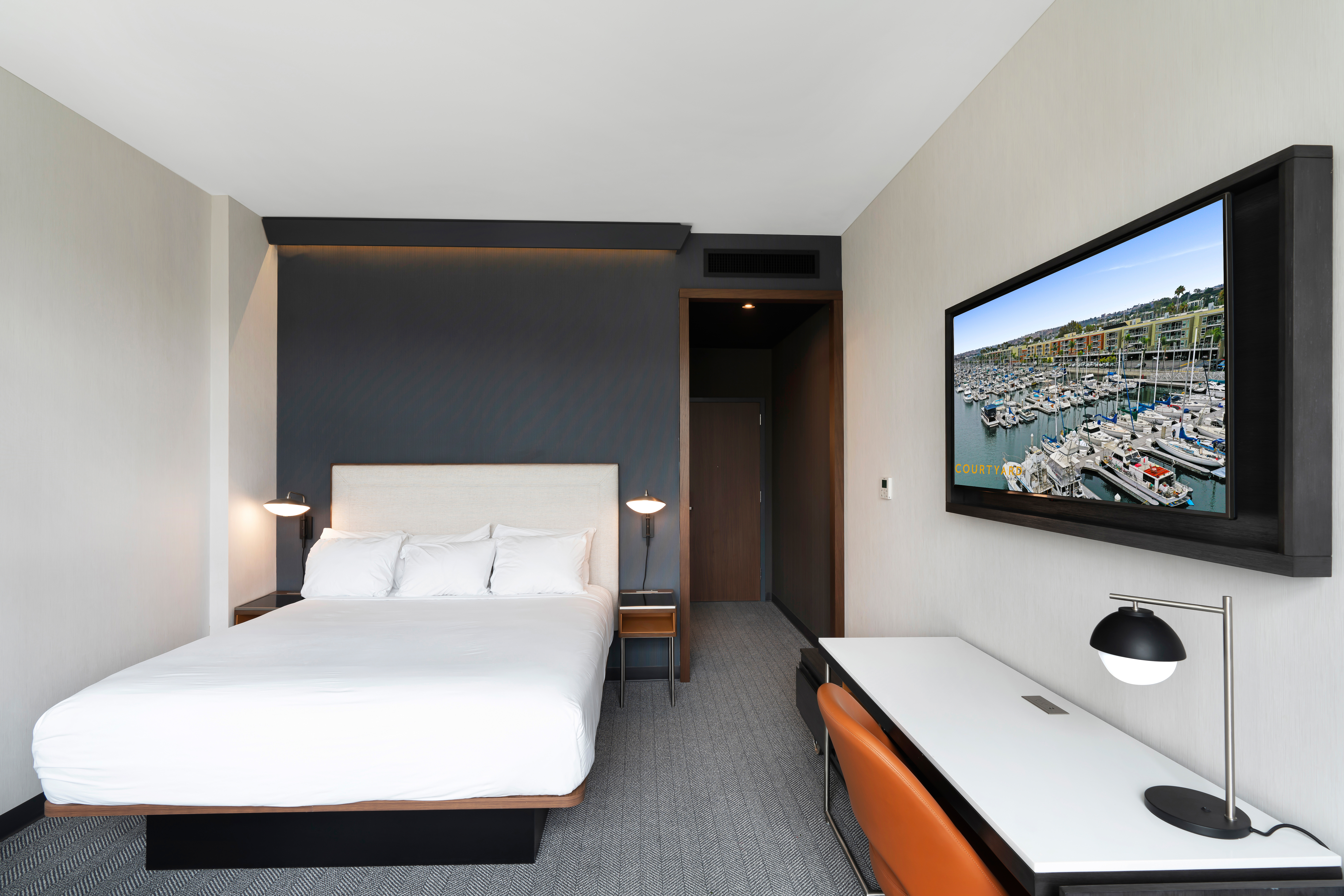Guest room showing bed and flat screen TV at new Courtyard by Marriott