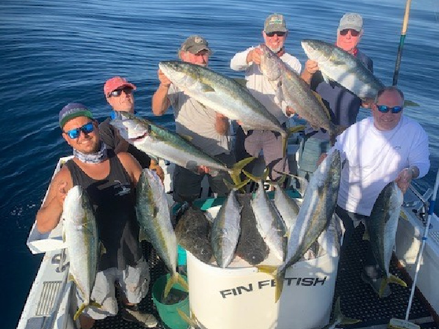 Group on a boat showing fish caught from fishing charter