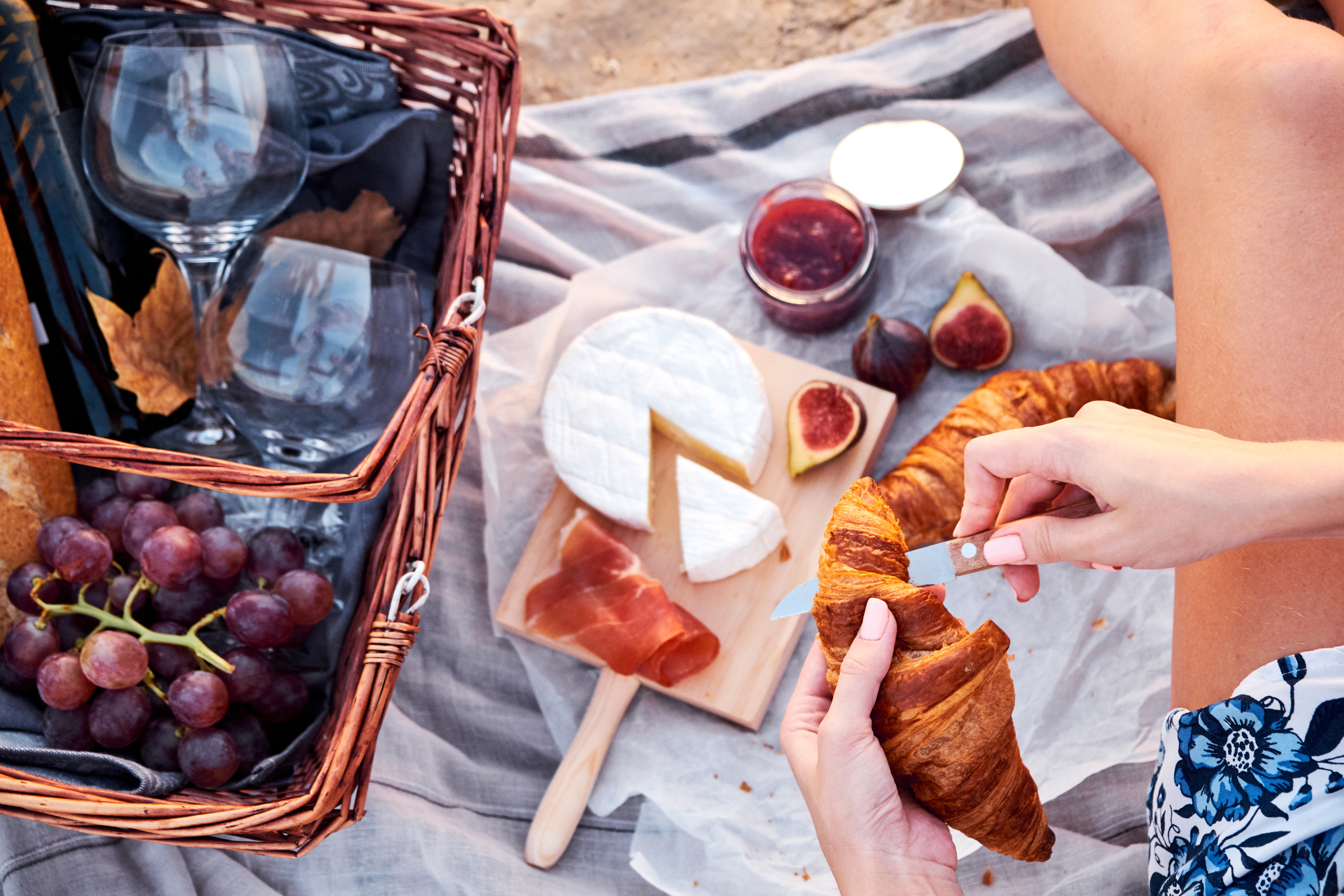 Food in a picnic basket and picnic blanket on the beach