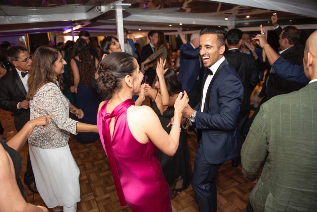 People dancing on dance floor and smiling aboard private yacht