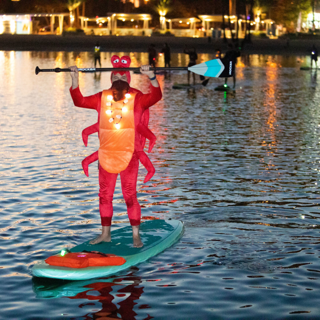 Person paddling in the water wearing a lobster costume