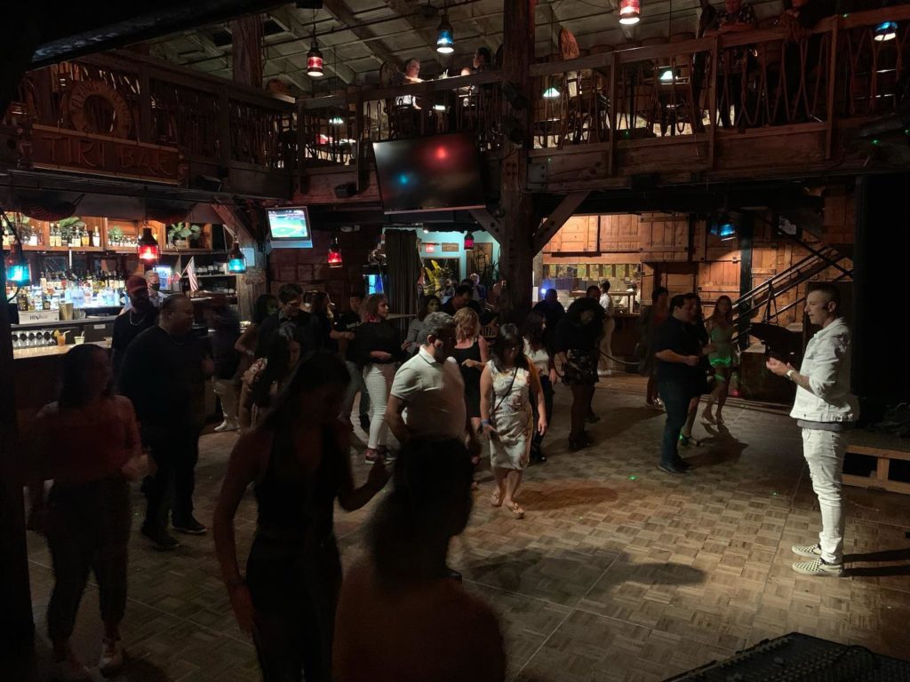 People learning to salsa on a dance floor