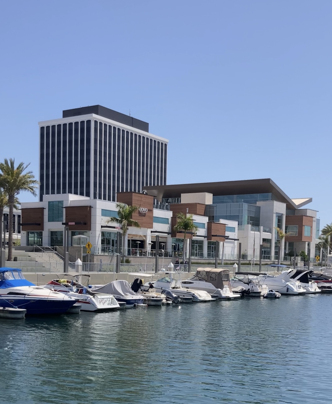 Shopping building with harbor and boats in marina