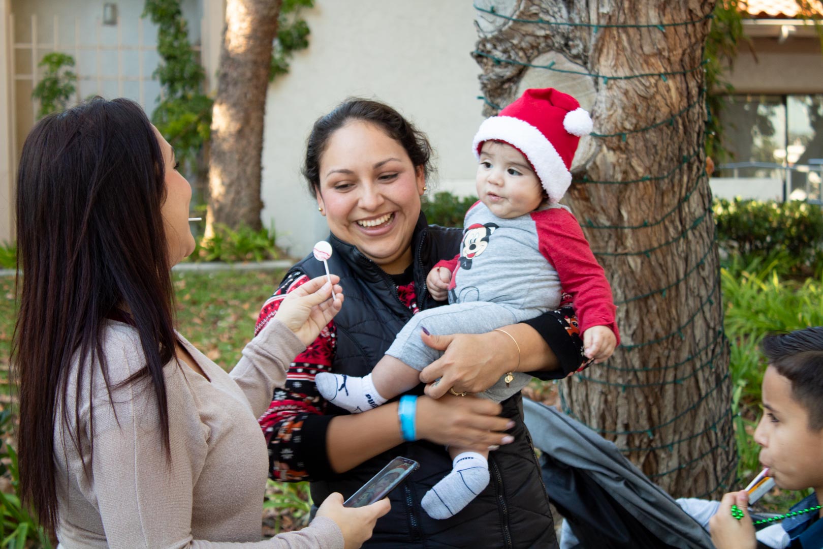 Woman holding baby with Santa hat