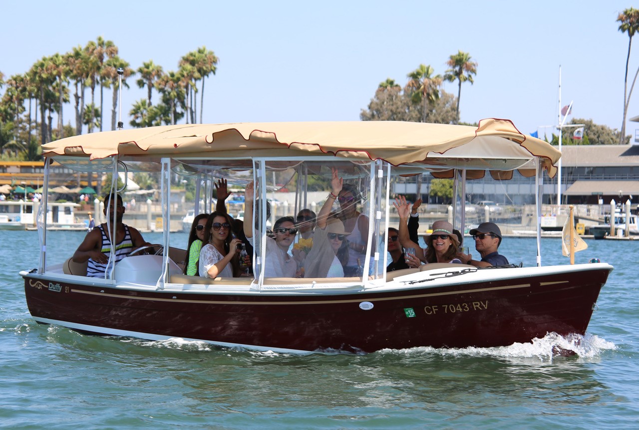 Group of people sitting inside duffy boat in the ocean