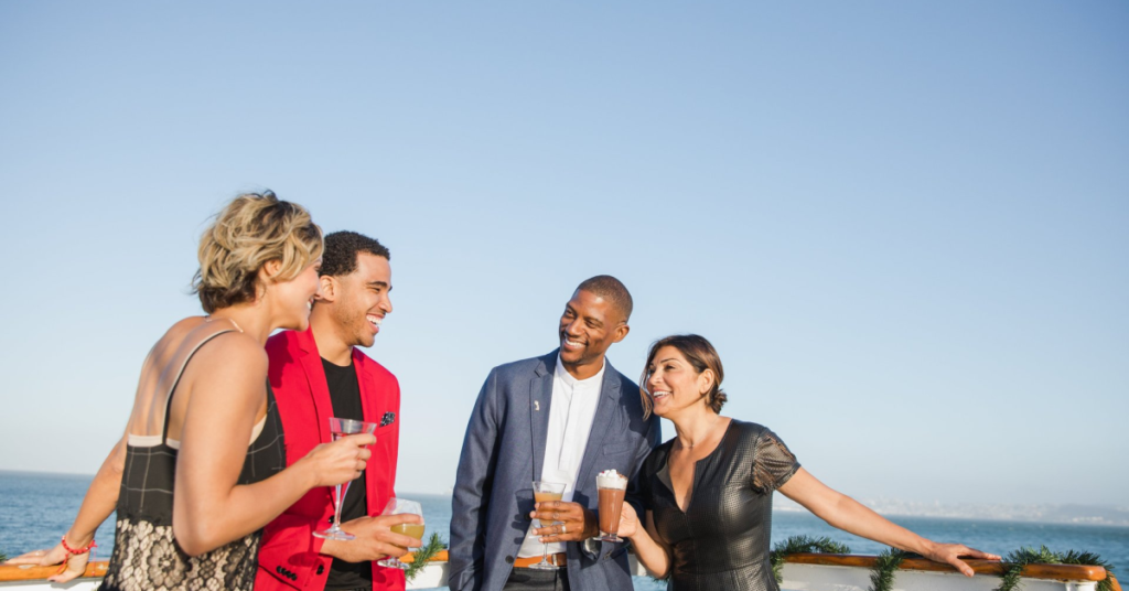 Four people celebrating the holiday season with drinks on a yacht