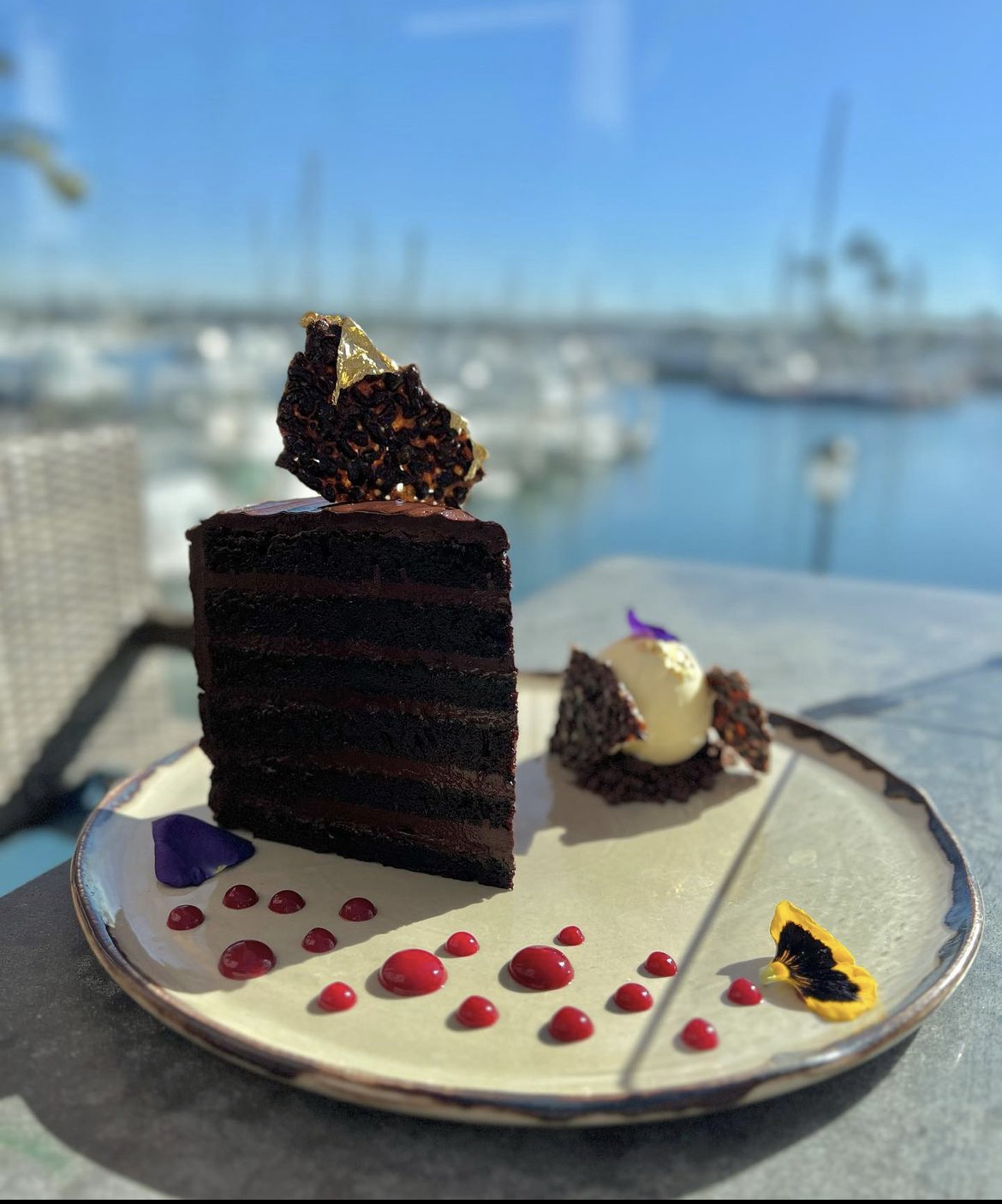 slice of chocolate cake on a plate overlooking harbor and boats