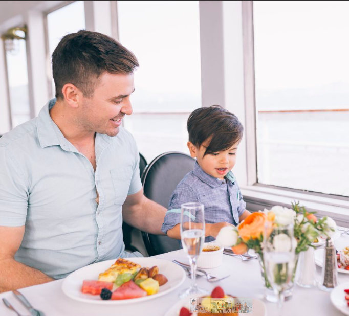 Father and son eating at a table in yacht dining cruise