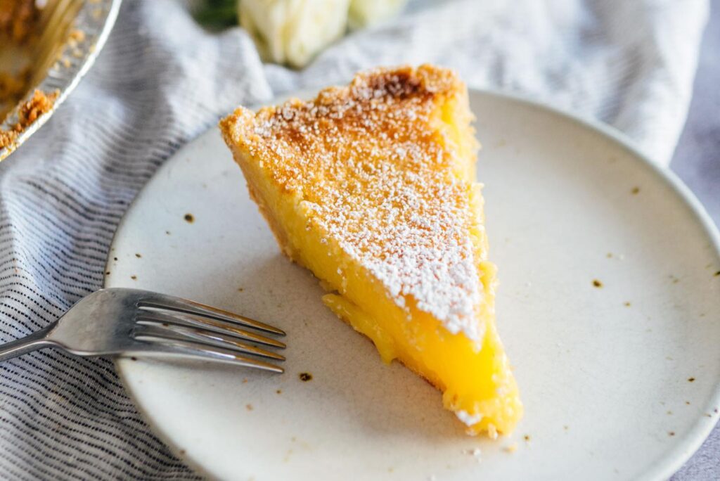 Slice of lemon pie on a plate with fork